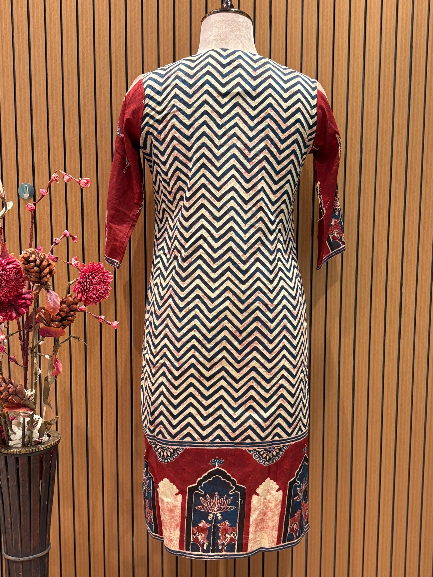 This vibrant red ethnic suit features a bold chevron-printed kurta