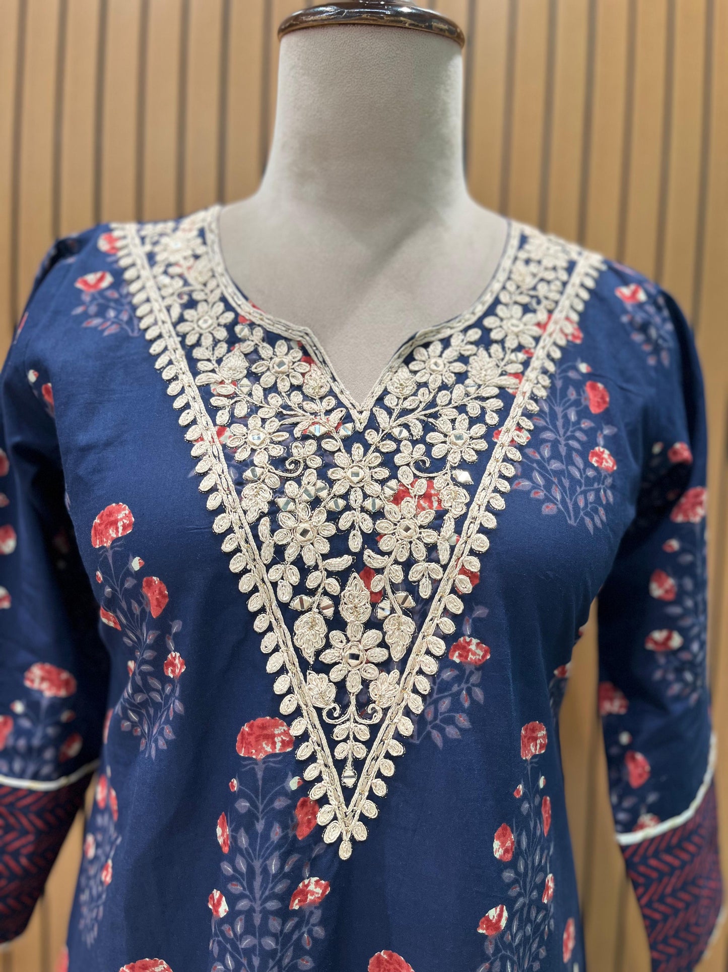 Elegant navy blue three-piece suit features floral embroidery on the neckline,