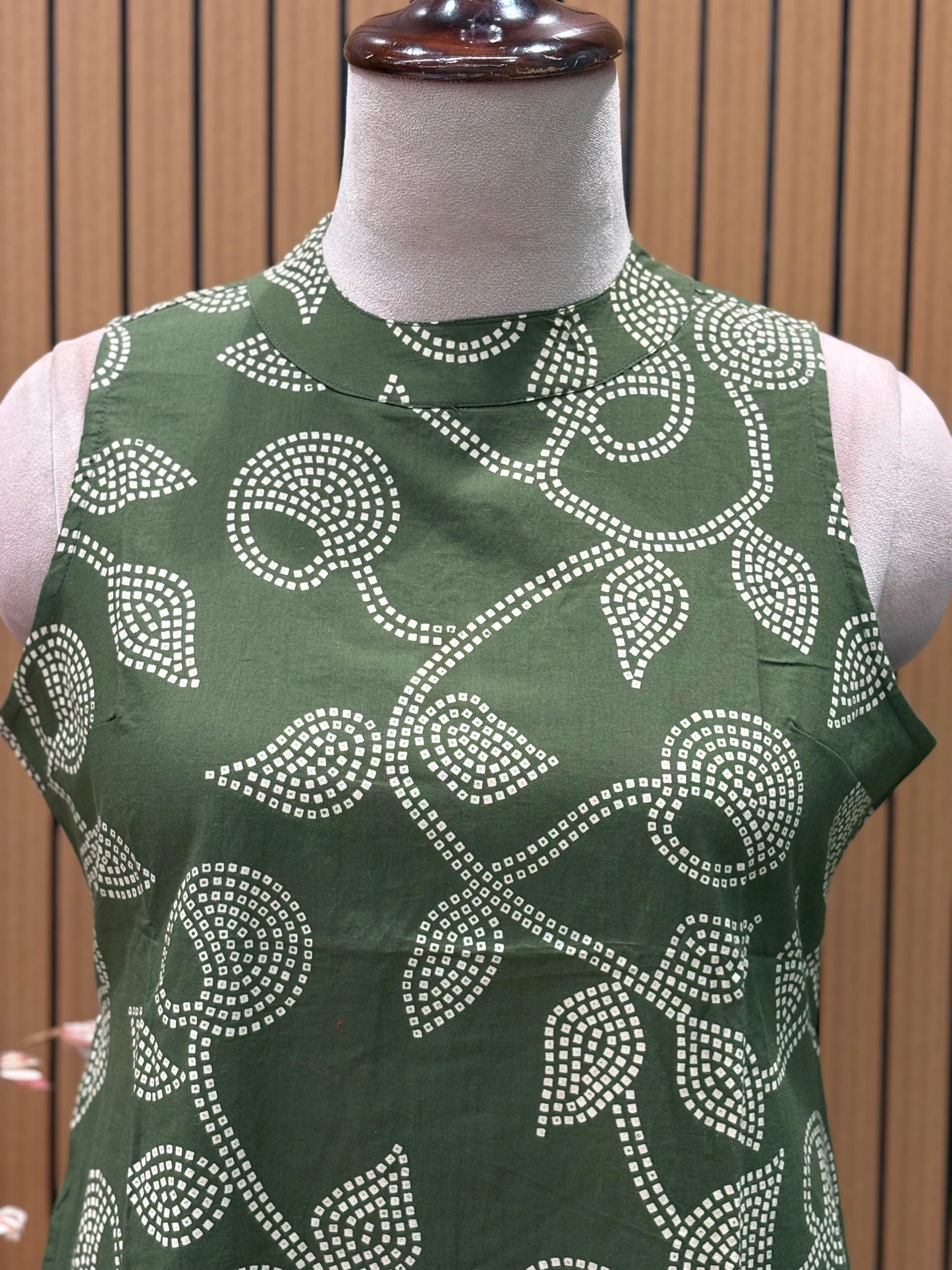 Sleeveless green flared dress with white swirl-leaf