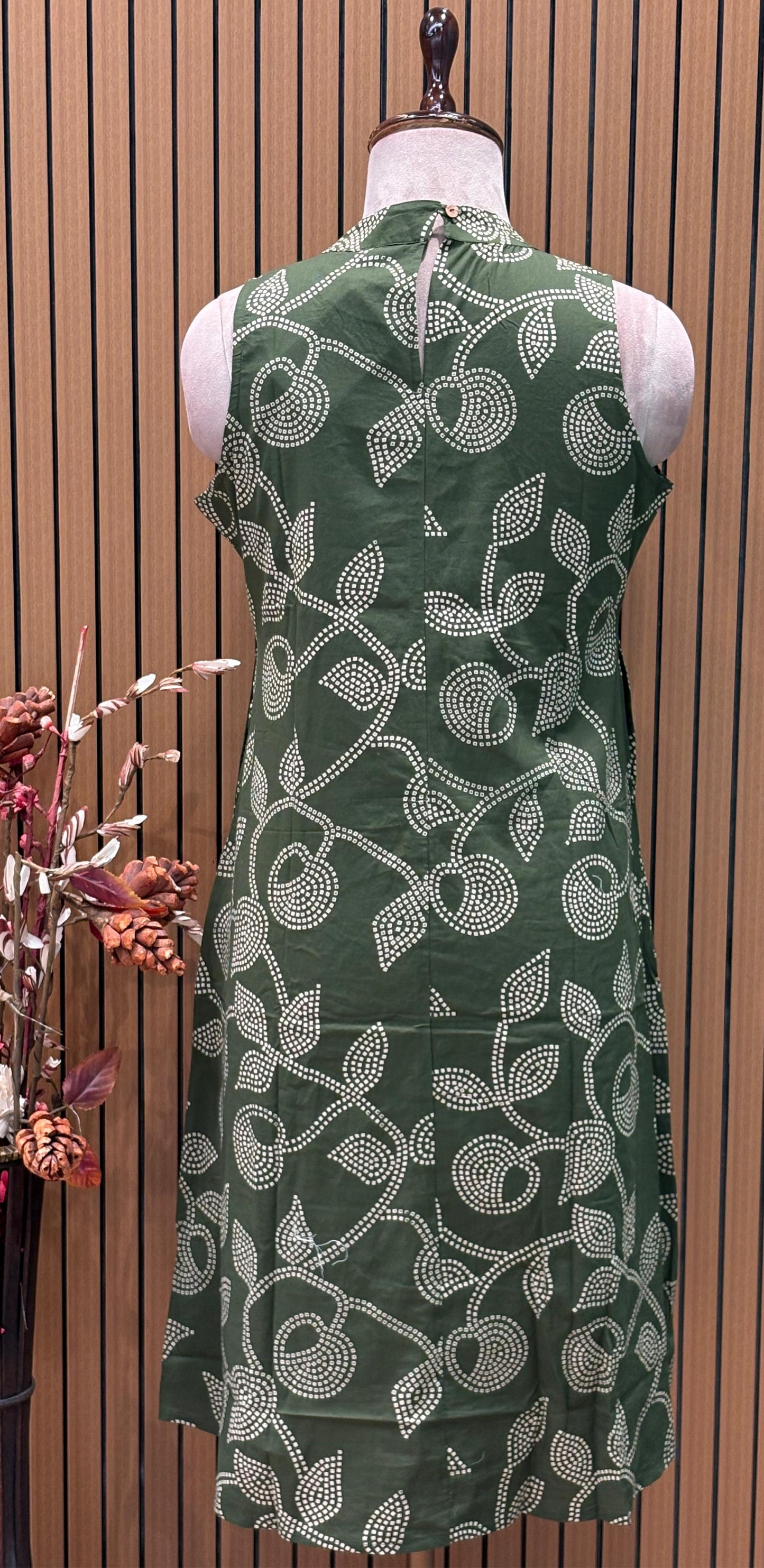Sleeveless green flared dress with white swirl-leaf