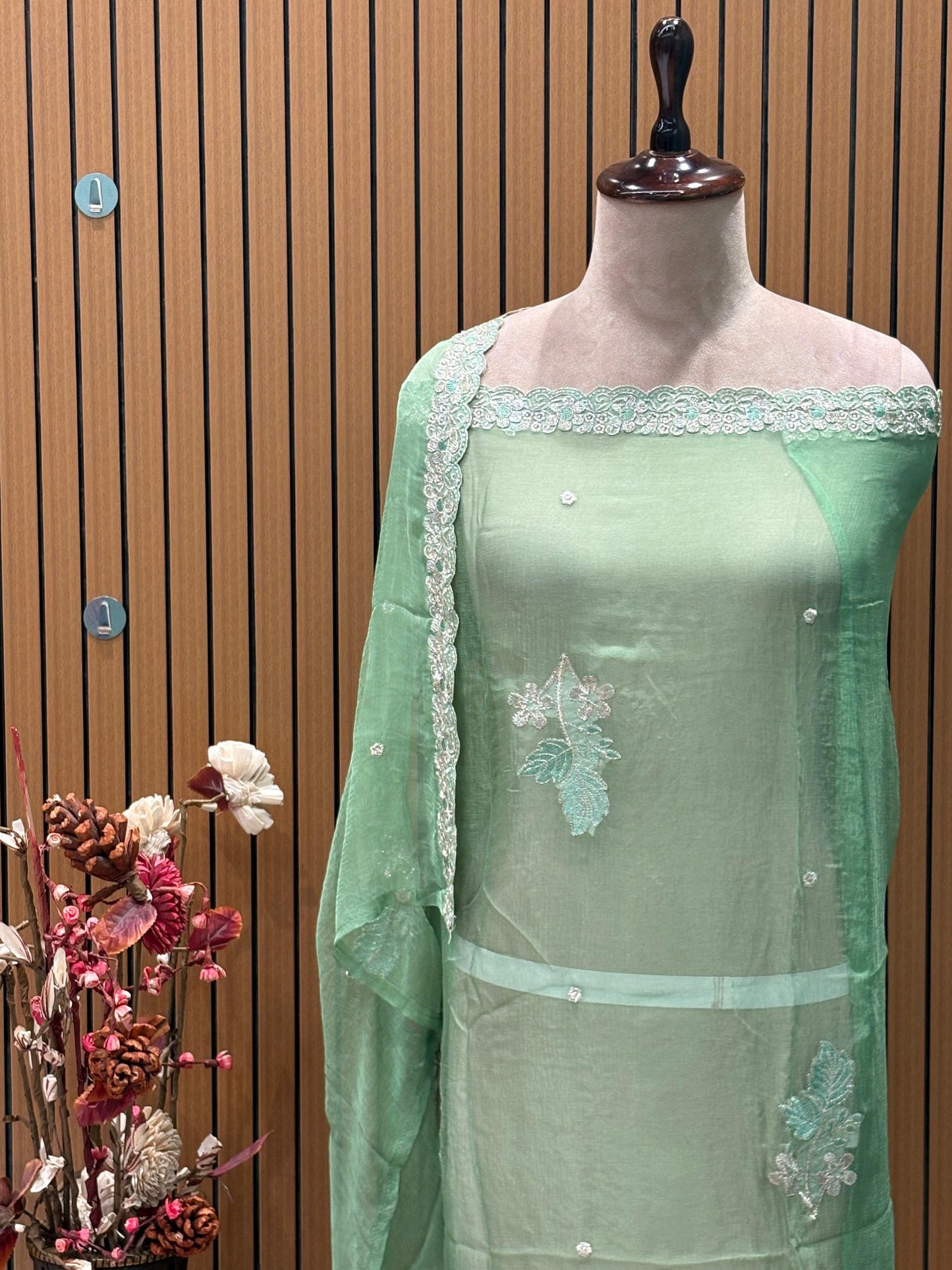 This elegant unstitched suit set features a rich organza fabric