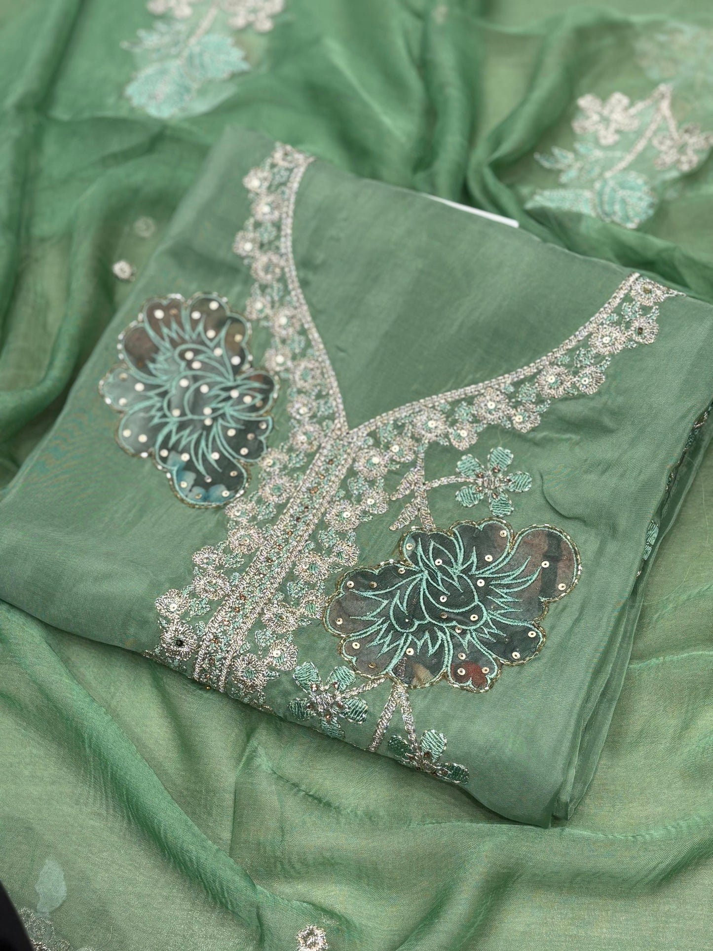 This elegant unstitched suit set features a rich organza fabric