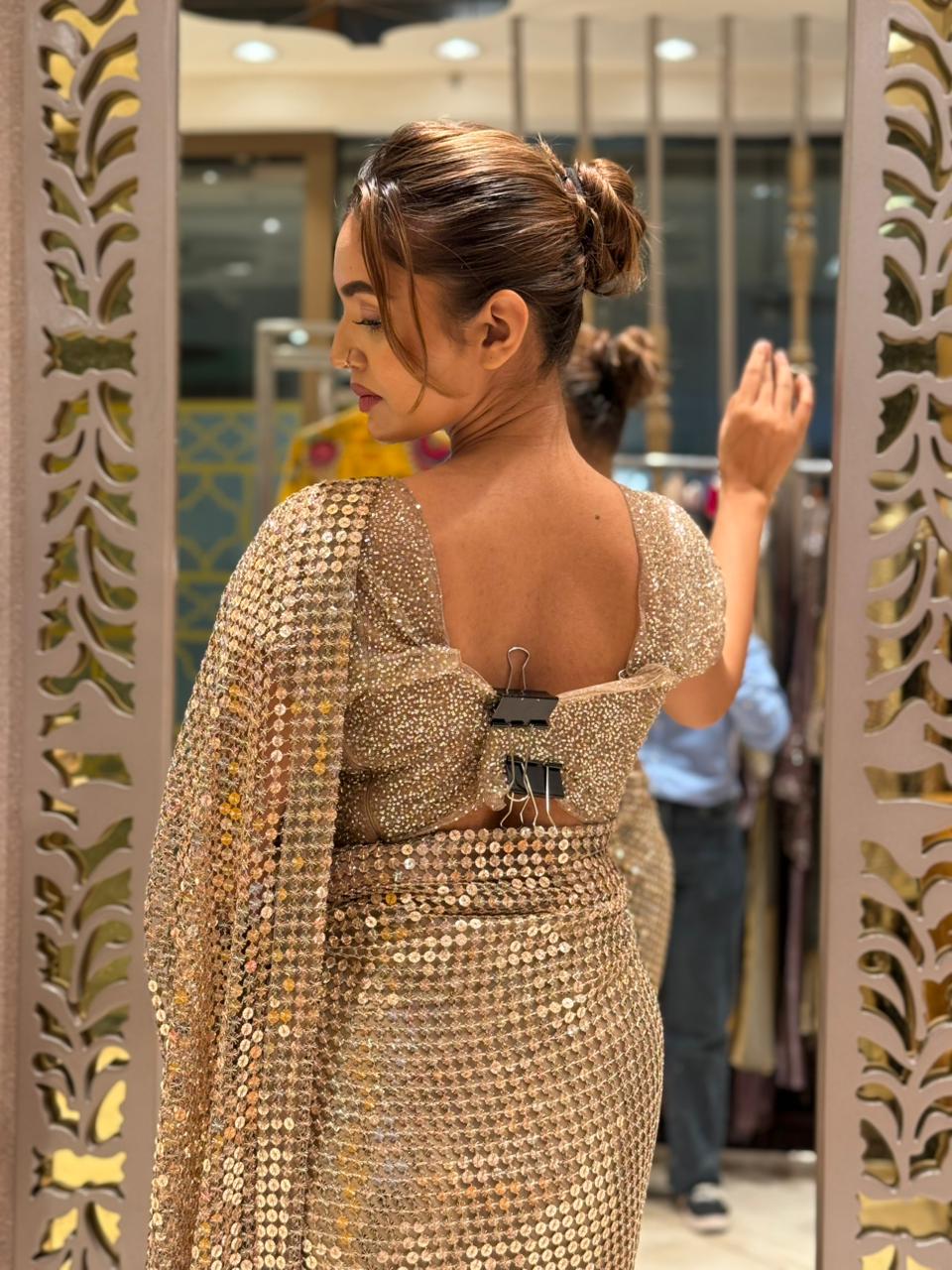 Gold shimmer soft-net saree featuring a stitched blouse