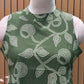 Sleeveless green flared dress with white swirl-leaf