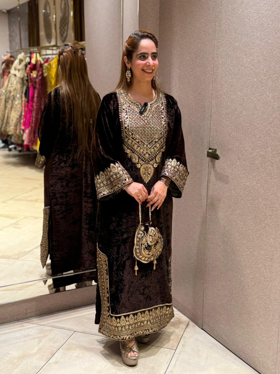 Royal velvet outfit with intricate golden embroidery and handcrafted potli bag