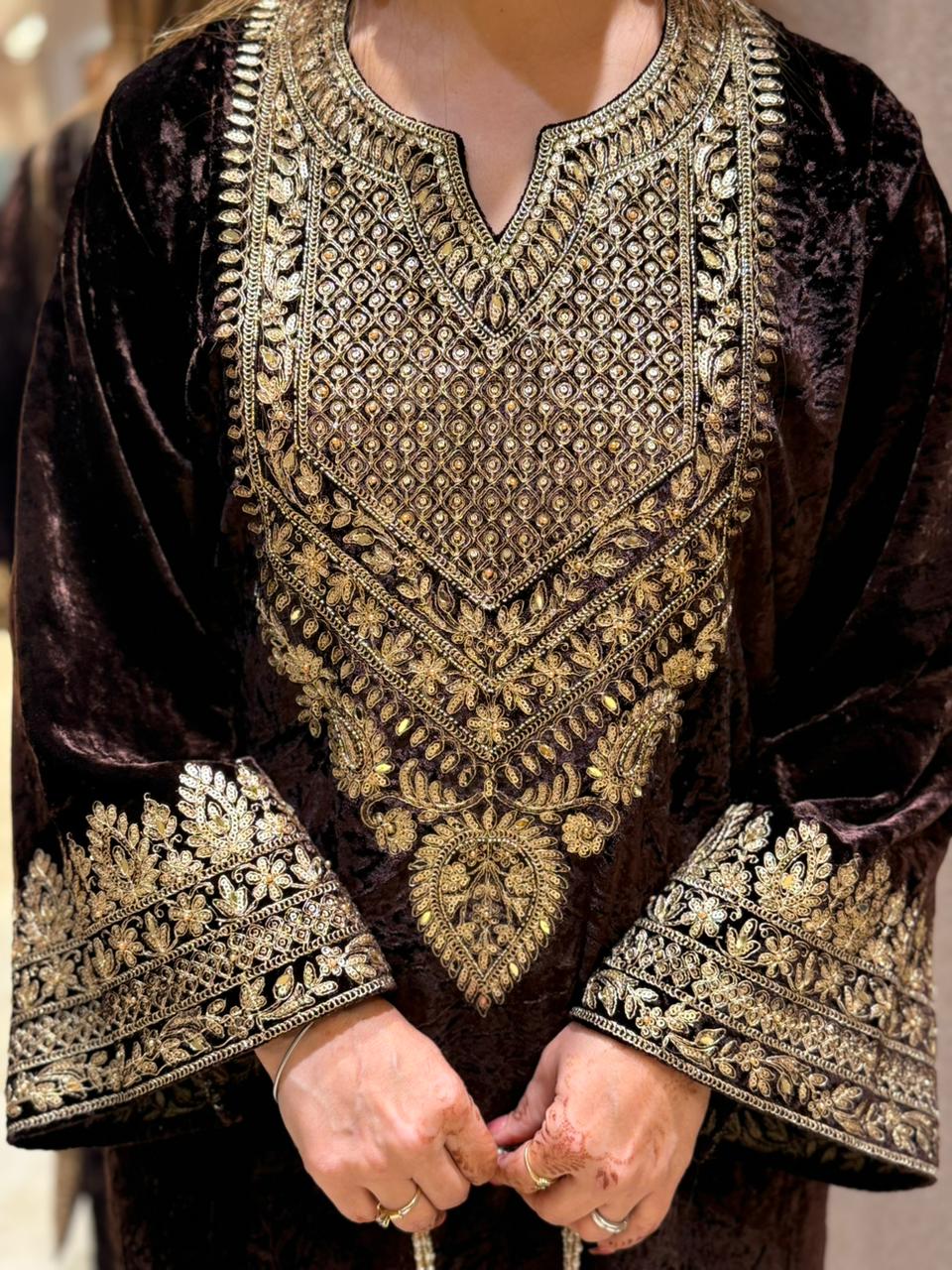 Royal velvet outfit with intricate golden embroidery and handcrafted potli bag