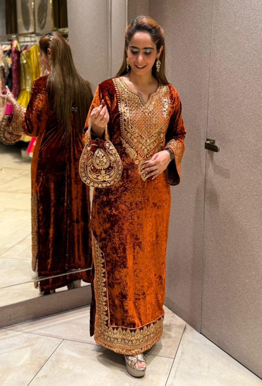 Royal velvet outfit with intricate golden embroidery and handcrafted potli bag