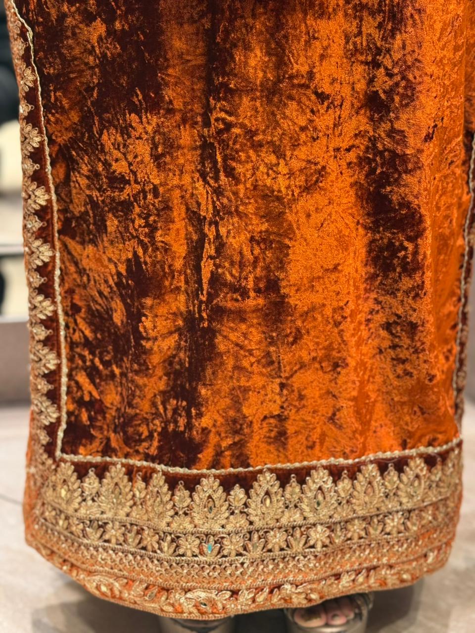 Royal velvet outfit with intricate golden embroidery and handcrafted potli bag